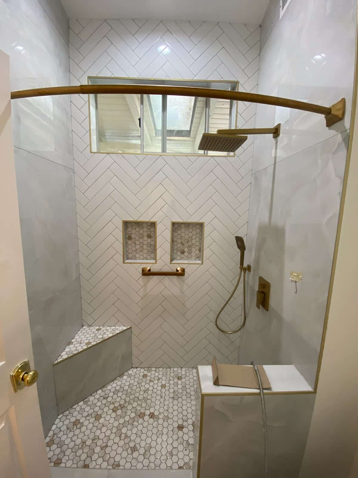 White herringbone walk-in shower with gold fixtures in Reseda