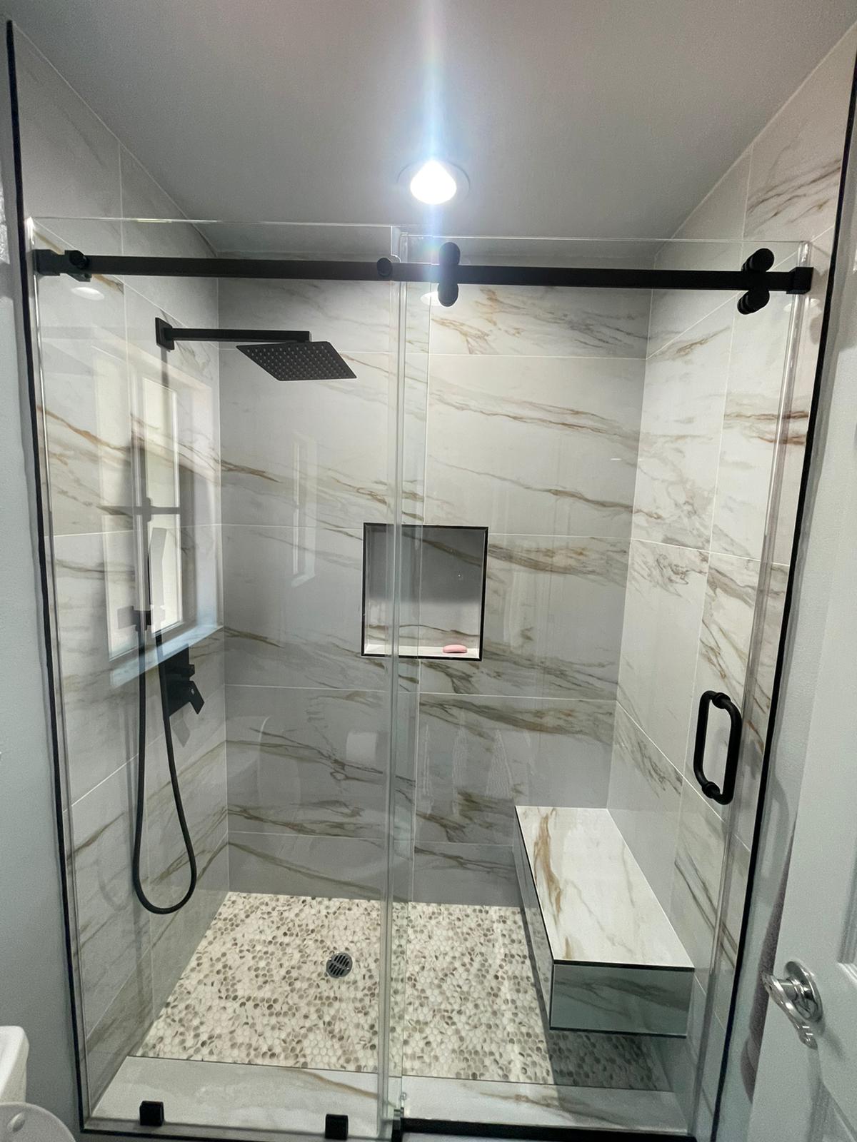 Marble-look shower with black sliding rail enclosure in Reseda